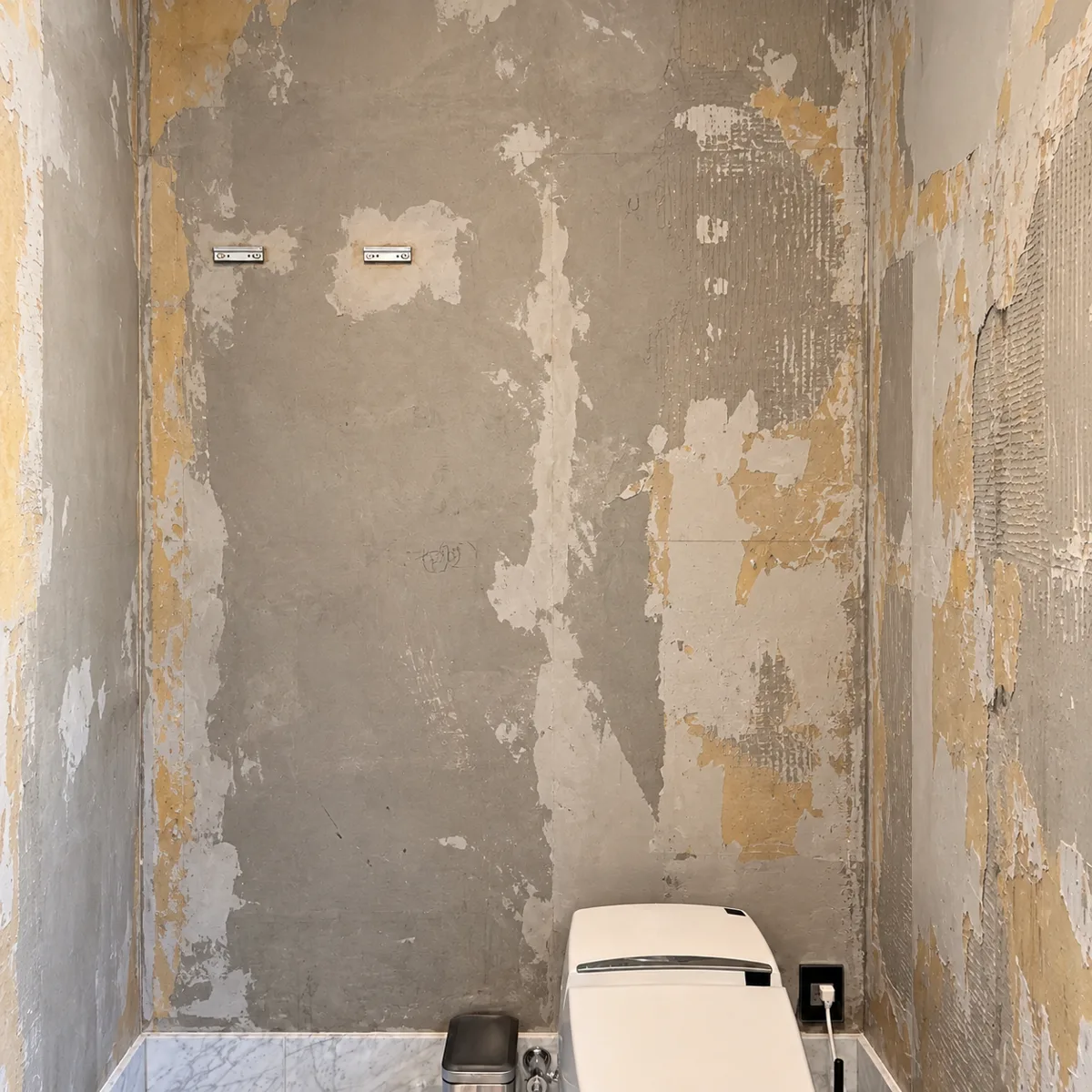 Same room before: walls with old wallpaper stripped and damaged surface