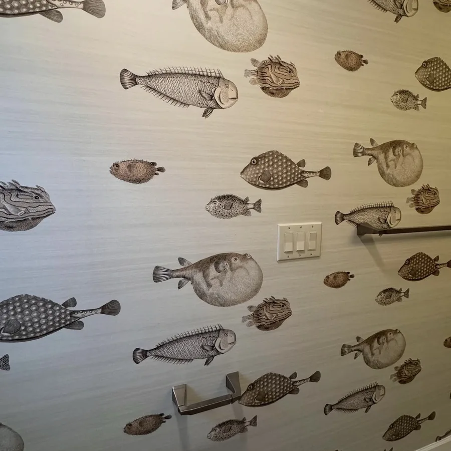 Fish print grasscloth wallpaper installed in a powder room