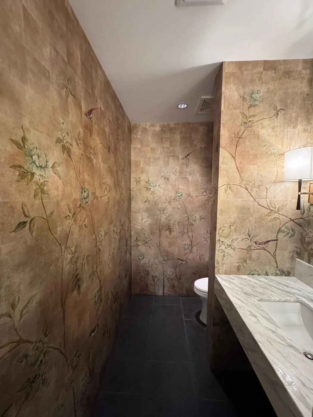 Panoramic gold chinoiserie mural wallcovering in a long bathroom