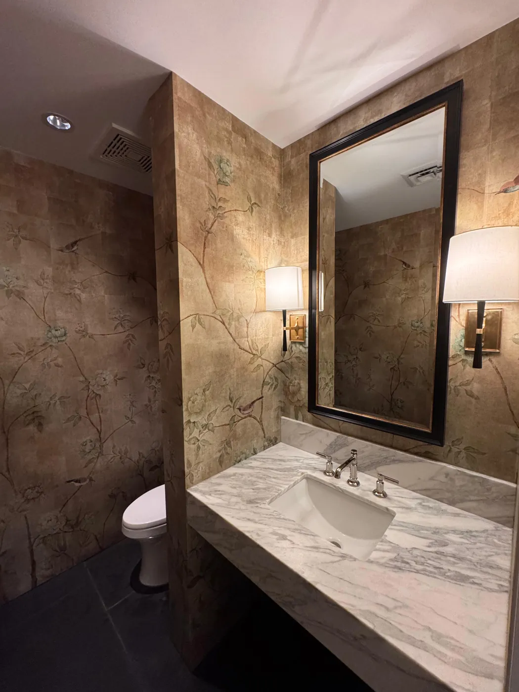 Gold-leaf chinoiserie mural wallpaper in a powder room with marble vanity