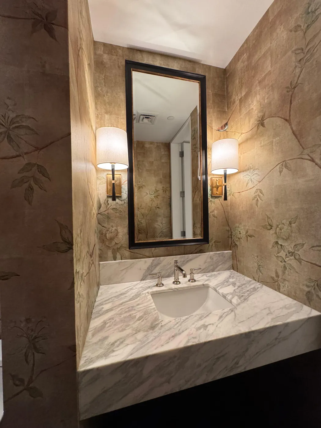 Hand-painted style gold chinoiserie wallpaper framing a vanity mirror