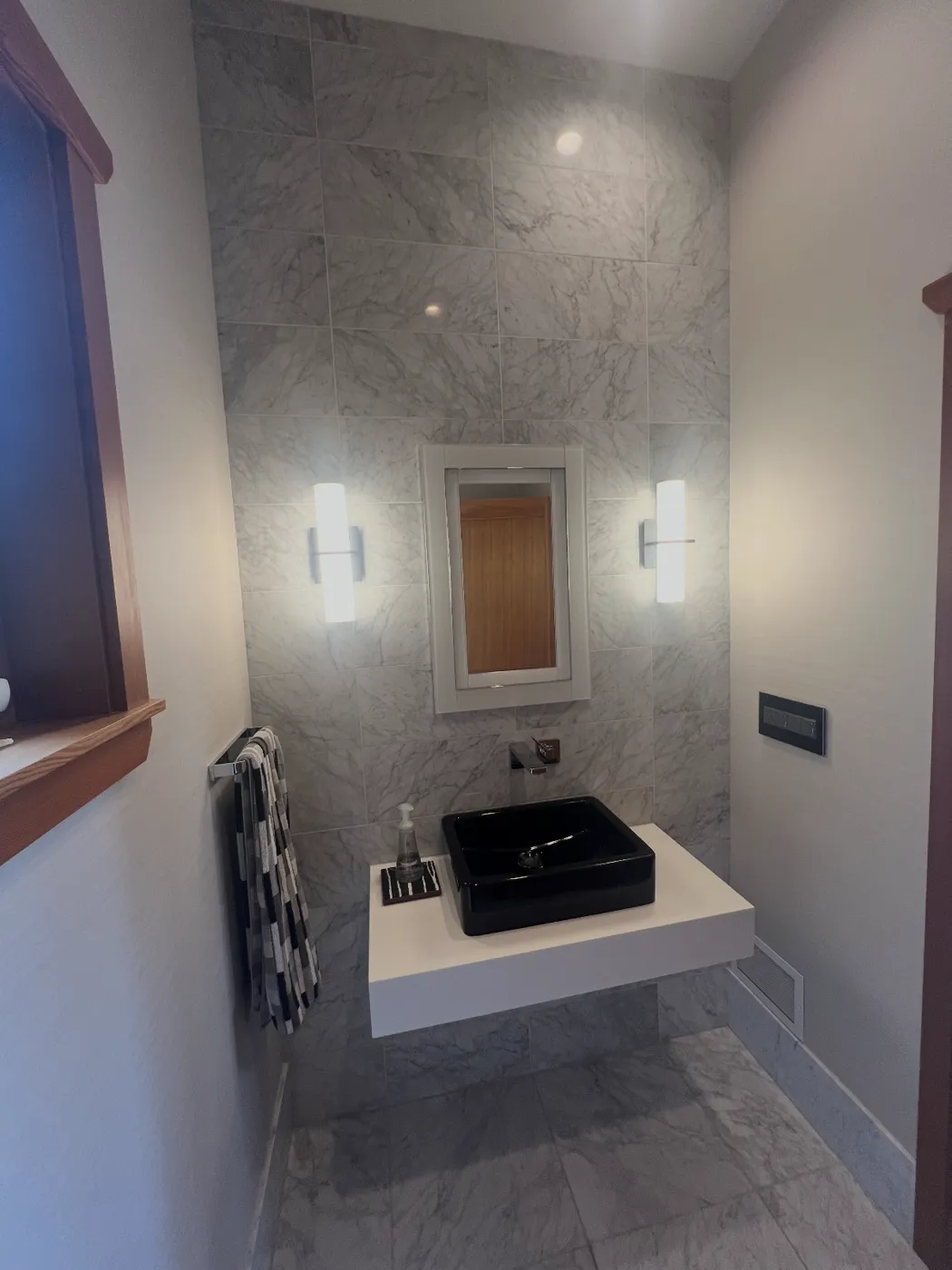 Modern powder room with marble feature wall and floating vanity