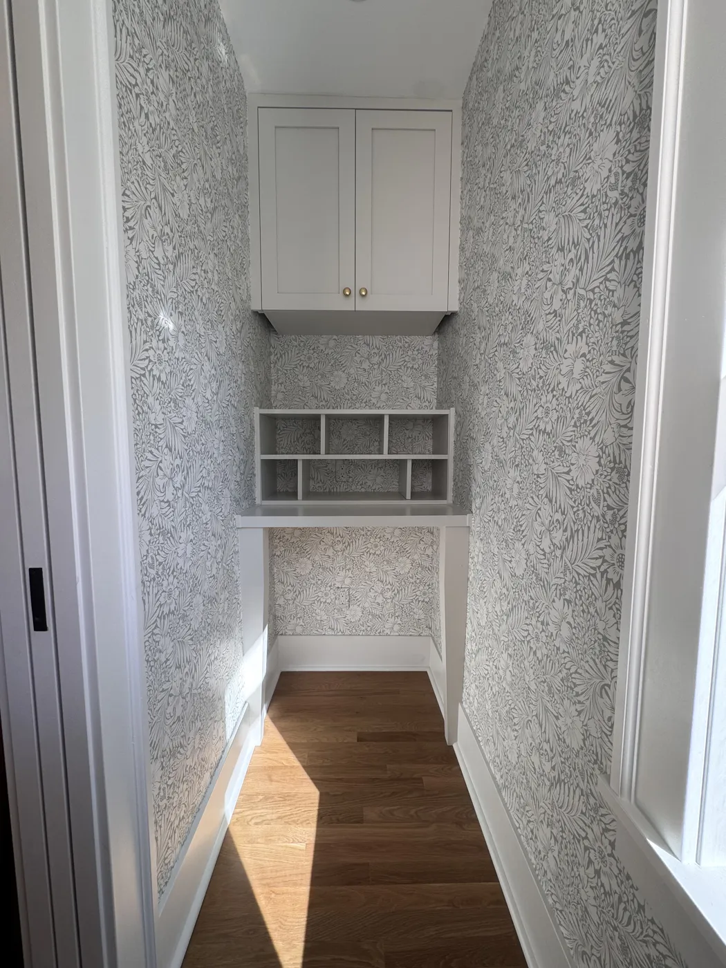 Sage floral wallpaper in a built-in desk nook with cubbies